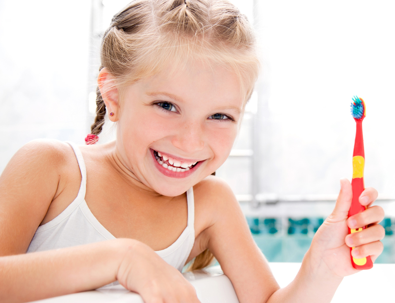 Little girl brushing teeth in bath